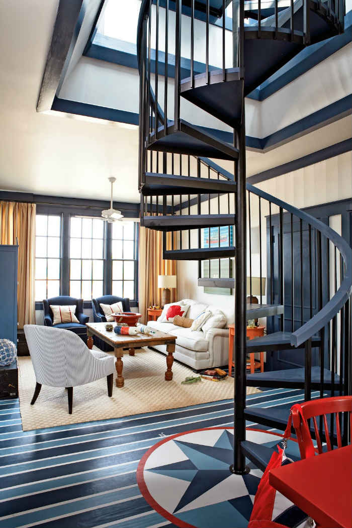 Όμορφος συνδυασμός σκούρου ξύλου και μπλε σκαλοπατιών από μια σκάλα που δανείζεται το χρώμα της από το υπόλοιπο δωμάτιο.