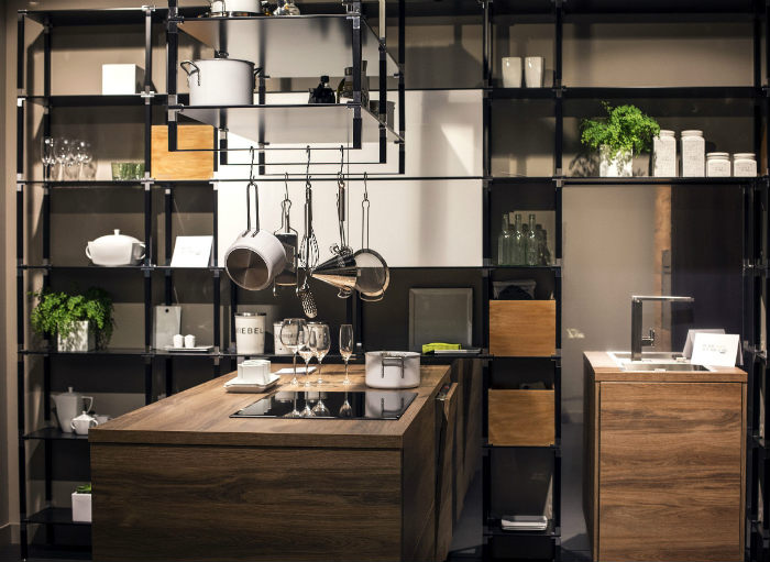 Ράφια βιομηχανικού σχεδιασμού σε μαύρο ματ. Κάποια από αυτά στηρίζονται από το ταβάνι.