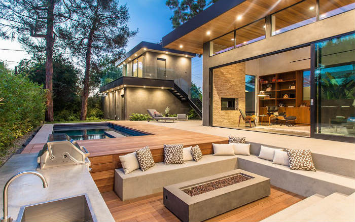 ξύλινο deck με εστία δίπλα σε bbq και πισίνα