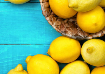 Λεμόνια σε καλάθι και τυρκουάζ τραπέζι.