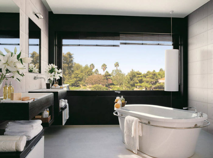 Μπάνιο σε άσπρο και μαύρο με μπανιέρα ελεύθερης εγκατάστασης.