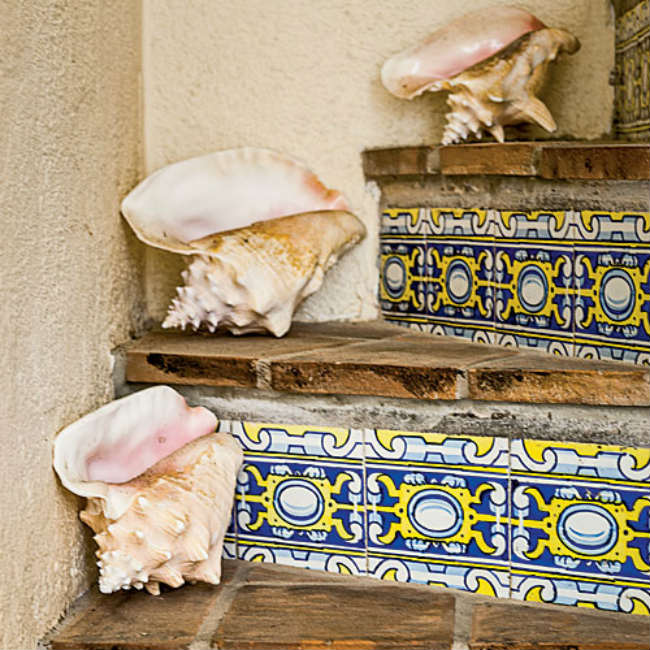 Μια σκάλα με ethnic-coastal και πλακάκια ζωγραφισμένα στο χέρι.