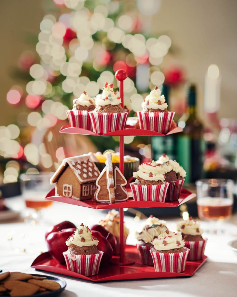 Κόκκινη βάση σερβιρίσματος με cupcakes και σπιτάκι από μελόψωμο